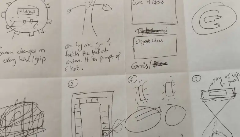 Handwritten Crazy 8s sketches on a sheet of paper folded into eight panels, showing rough drawings of product ideas