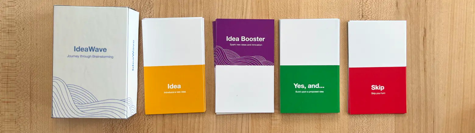 The IdeaWave card game: a white “Journey through Brainstorming” box beside yellow Idea, purple Idea Booster, green Yes, and… and red Skip card decks